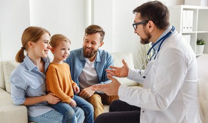 Friendly doctor speaking with boy and parents.