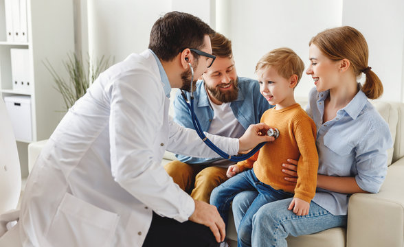 Doctor listening lungs of boy during family check up.
