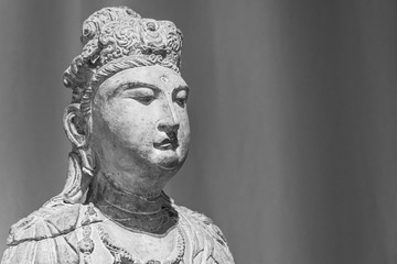 Black and white photo showing face of asian statue