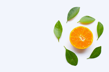 Fresh orange citrus fruit with green leaves on white.
