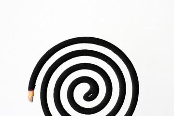 Black spiral mosquito repellent coil on white background.