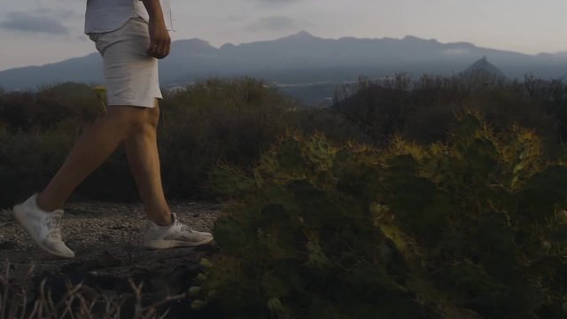 A traveler with a backpack in the mountains on an island all in white walks in the mountains.