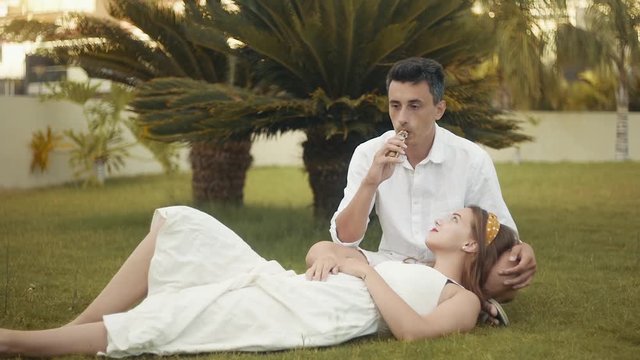 A vape woman and man. Couple on vacation, under a palm tree. Rest, smoking, nicotine, pleasure, danger. Vape liquid. Vaping THC e cigarette.