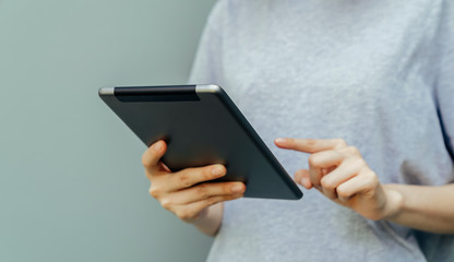 Closeup of young woman hand holding digital tablet.