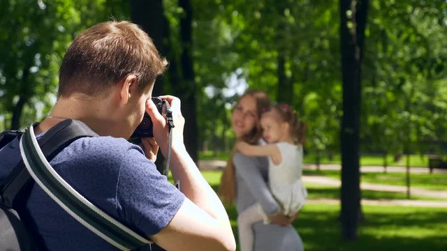 Photographer Shooting Taking Pictures of Mother with Child. Backstage Photo Session in City Park Background. 2x Slow motion 1/2 60 FPS