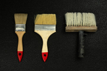 Paint brushes on a black background, top view, flat lay