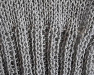 Gray knitted texture knitted on needles with a two-in-two elastic band