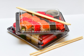 Sushi rolls pack in plastic container on white background