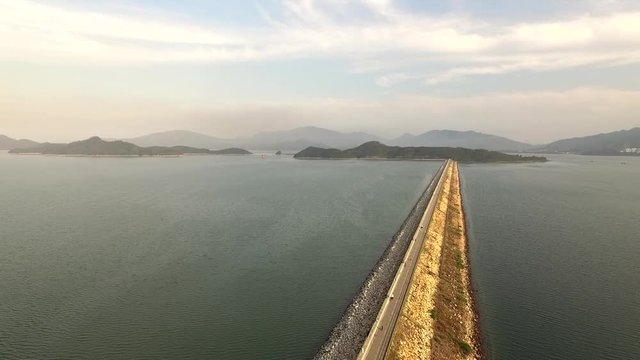 Drone footage of a sunset at Tai Mei Tuk Reservoir with mountains and the river in the background  tlit down shot in golden hour