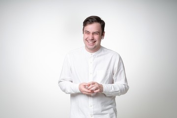 smiling guy with wireless earphones in white shirt