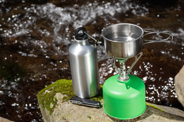 沢をバックにキャンプ用品