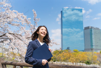 ビジネスウーマン　満開の桜　青空　高層ビル