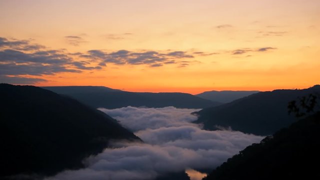 Seamless loop cinemagraph of mountains fog mist clouds moving morning above new river gorge valley in Grandview Overlook, West Virginia during colorful sunrise 