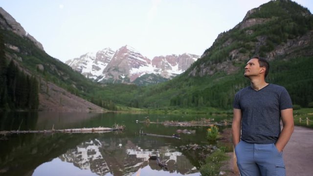 Maroon Bells lake at sunrise cinemagraph seamless loop of young man standing in Aspen, Colorado during blue hour dawn with rocky mountain peak and snow