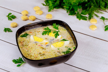 Healty creamy vegetable soup with egg and crackers.