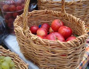 Red apples in a basket from willow vines. Concept of  village, harvest.