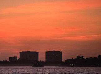 Fototapeta premium sunset over the city, sky, skyline, silhouette, clouds, vibrant, colorful, red, urban, horizon, building