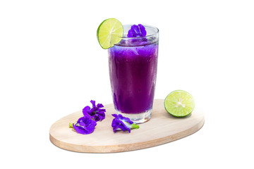 Butterfly pea juice with ice in transparent cup serve on Wooden sheet with flower and lemon (Clitoria ternatea).