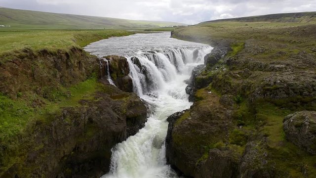 Slow motion seamless loop cinemagraph of Kolufossar water waterfall falls in Iceland with canyon Kolugljufur gorge landscape view