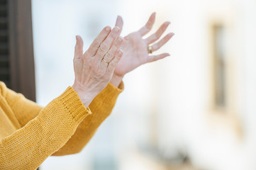 Close-up of hands clapping from the window