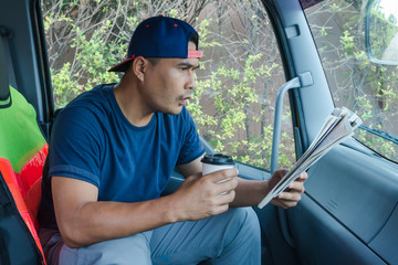 A man reading a newspaper in the car
