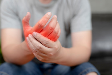A young man with pain in his hand because of hard work, Ache in human body , office syndrome,Bone and joint disease, Concept healthcare and medical.
