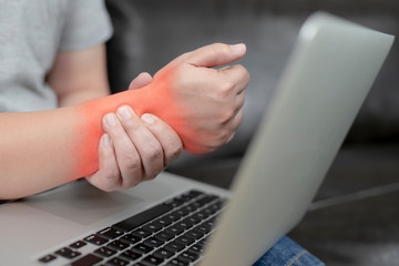A young man with pain in his hand because of hard work, Ache in human body , office syndrome,Bone and joint disease, Concept healthcare and medical.