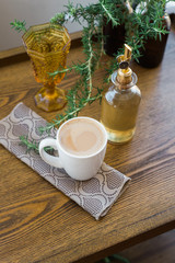 Wood coffee table with mug cup of coffee and flavored syrup on tea towel