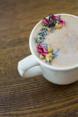 mug cup of coffee with dried flowers and herbs on top close up