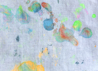 White fabric with colorful ink drops texture.
