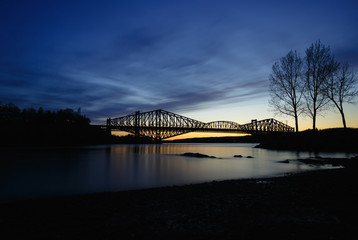Quebec bridge over the St Lawrence river after sunset in spring. Evening long exposure. Shore of Chaudiere river jonction