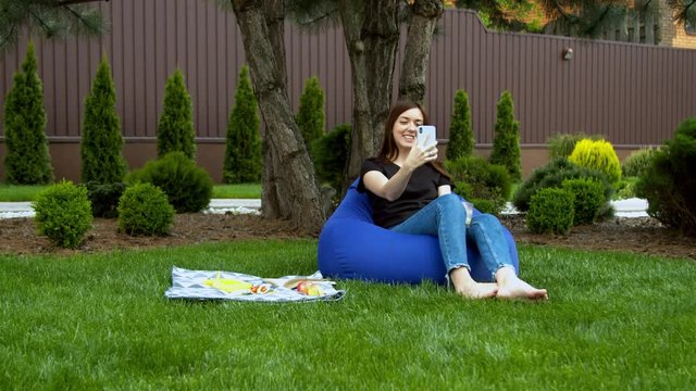 Young woman having video call in garden