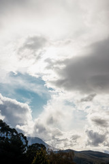 sunlight and rays of light shining through the clouds on top of the mountains in Tasmania