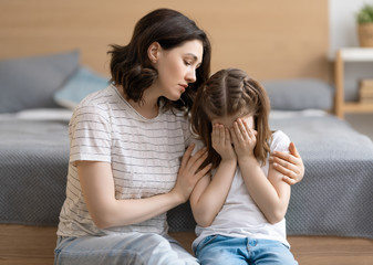 Mother is feeling sorry for a crying child.