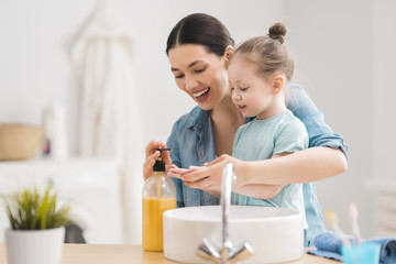 girl and her mother are washing hands