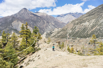 Fototapeta na wymiar Travel and trekking concept. Woman with backpack on trekking trail in himalayas mountains. Nepal.