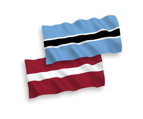National vector fabric wave flags of Latvia and Botswana isolated on white background. 1 to 2 proportion.
