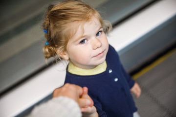 Adorable little toddler girl at the airport. Lovely child walking to the gate and going on family vacations by plane. Positive happy child.