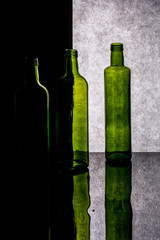 Still life with colored bottles with reflection on a dark background