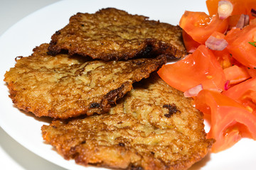 Polish potato pancakes with chopped tomato salad. Placki Ziemniaczane Recipe