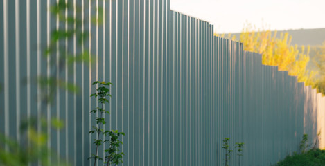 Metal gray fence made of profiled sheet, full insulation from the outside.