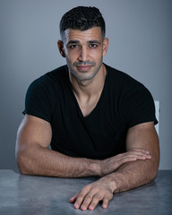 Handsome man in black t shirt on a grey background