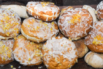 Fresh round small donuts during carnival or fast food festival, glazed with dark and white chocolate