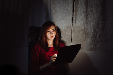 Asian woman working late at night with tablet digital gadget at home office work hard stressed serious emotion, Freelancer stay home business quarantine crisis coronavirus stay home dark room...