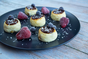 Cheesecakes with chocolate sauce with strawberries and black currant