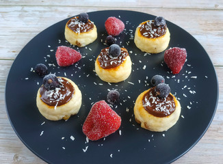 Cheesecakes with chocolate sauce with strawberries and black currant