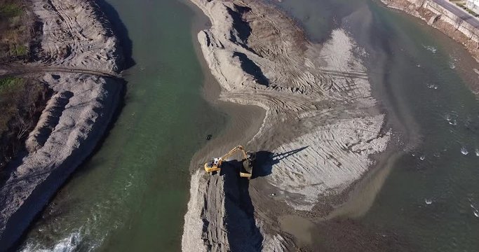 Revealing aerial Water escavators working on Arno river near Sieci town, Pontassieve, to avoid another Florence disaster flood afer latest November rainy long season. Sunny day Winter, Tuscany. Italy