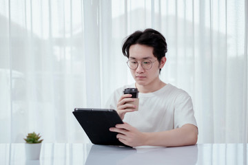 Asian man working from home with tablet self isolation from society to reduce risk, quarantine prevention coronavirus, covid-19 and study e-learing online education technology concept.