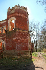 Naklejka premium old red brick tower in the abandoned ruined castle estate of baron Vrangel in Russia at sunny spring day