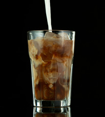 Pouring ice coffee drink on black background